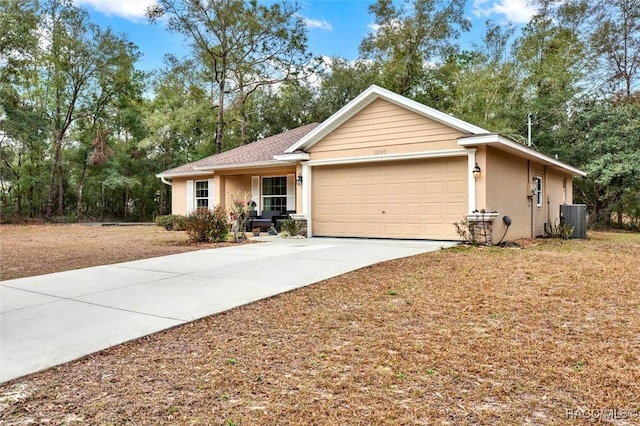 single story home with an attached garage, cooling unit, concrete driveway, and stucco siding