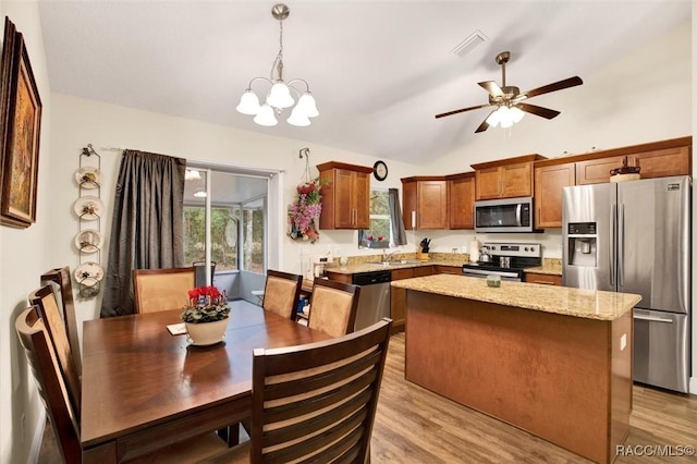 dining room featuring vaulted ceiling, light wood-style flooring, ceiling fan with notable chandelier, and visible vents