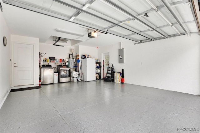 garage featuring a garage door opener, washing machine and dryer, freestanding refrigerator, and electric panel