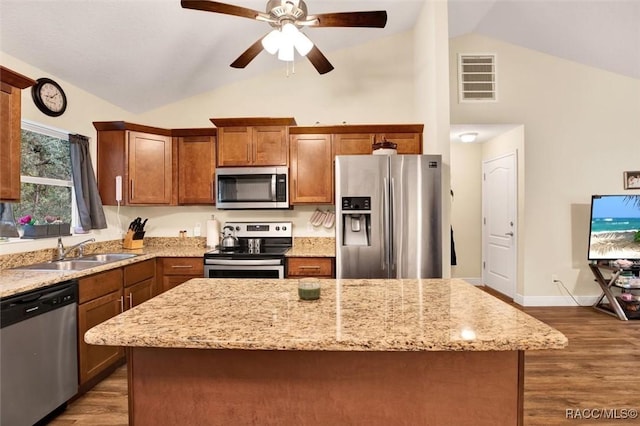 kitchen featuring appliances with stainless steel finishes, a center island, visible vents, and a sink