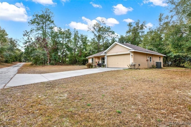 view of front of property featuring driveway, an attached garage, cooling unit, and stucco siding