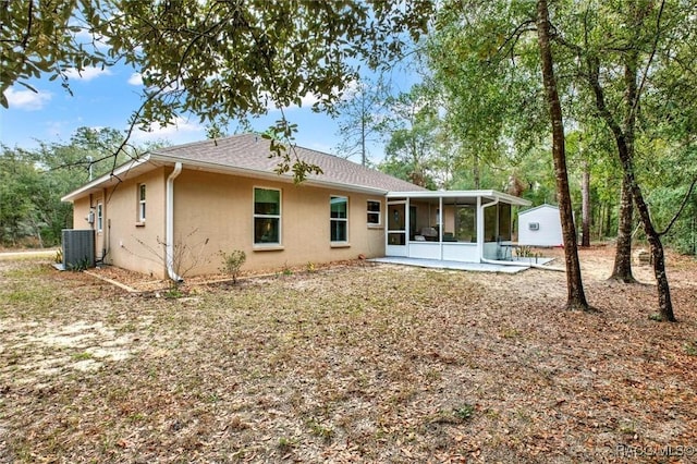 rear view of property with a patio, cooling unit, a sunroom, and stucco siding