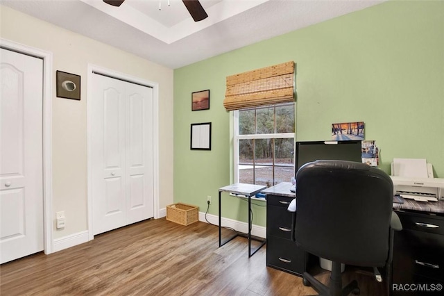 home office with wood finished floors, a ceiling fan, and baseboards