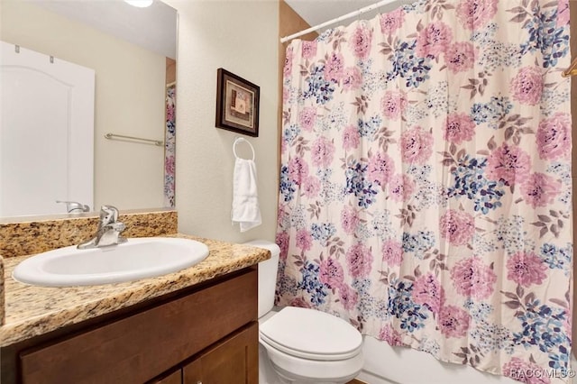 full bathroom with toilet and vanity