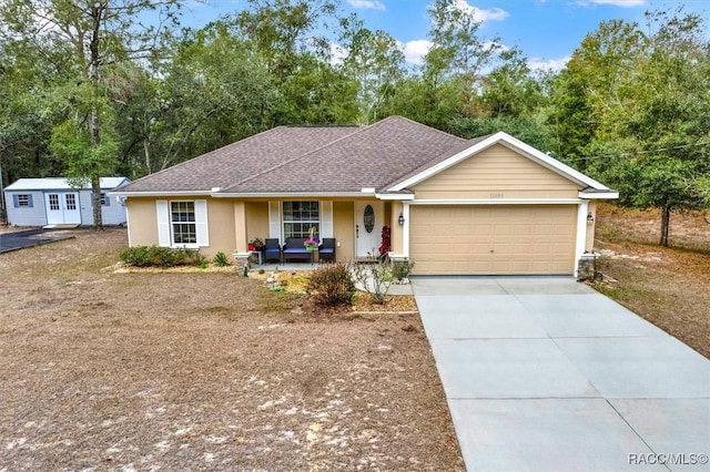 ranch-style home with concrete driveway, roof with shingles, an attached garage, and stucco siding