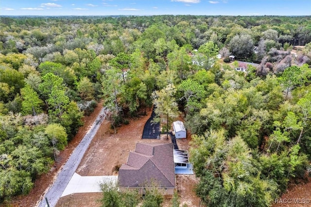 drone / aerial view with a wooded view