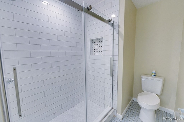 bathroom featuring tile patterned flooring, toilet, and walk in shower