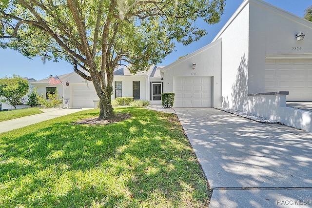 ranch-style home with a garage and a front lawn