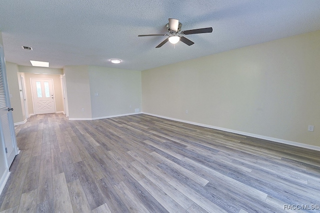 empty room featuring ceiling fan, wood-type flooring, and a textured ceiling