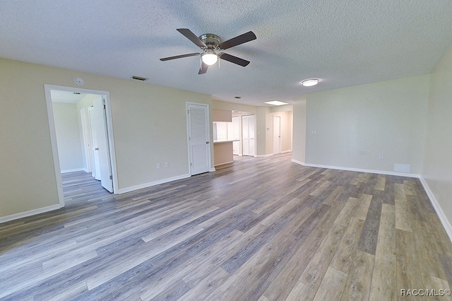 unfurnished living room featuring wood-type flooring, a textured ceiling, and ceiling fan