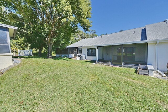 view of yard featuring central AC and a sunroom