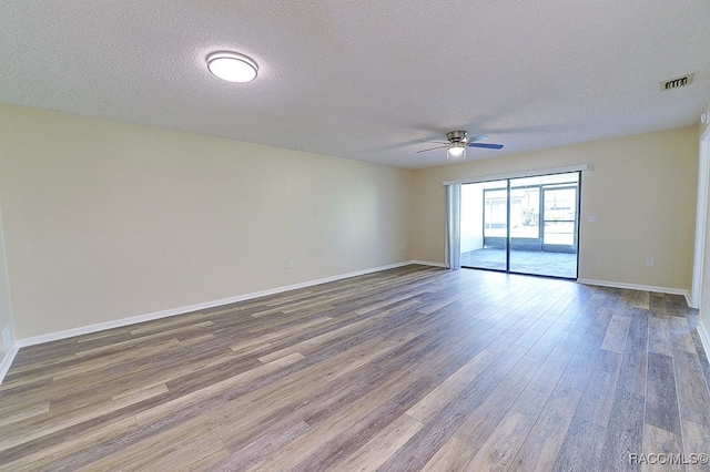 spare room with ceiling fan, wood-type flooring, and a textured ceiling