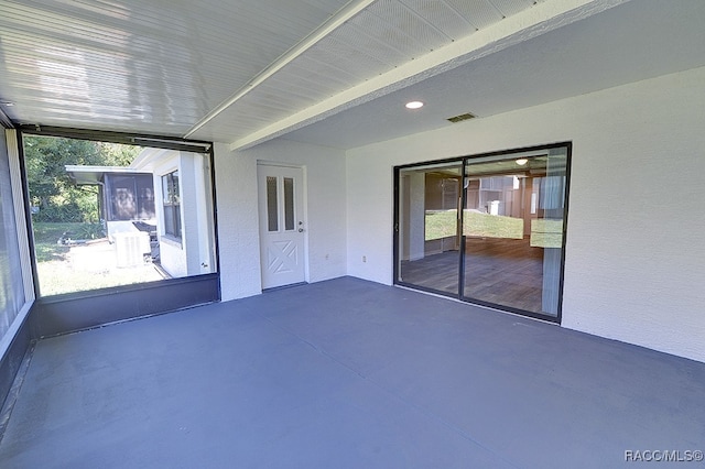 unfurnished sunroom with beam ceiling