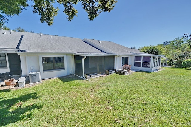 back of property featuring a sunroom, a yard, and cooling unit