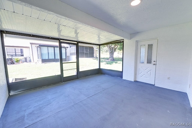 unfurnished sunroom with beamed ceiling and plenty of natural light