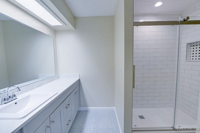 bathroom featuring tile patterned flooring, vanity, and tiled shower