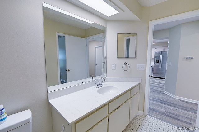 bathroom featuring hardwood / wood-style flooring, vanity, and toilet