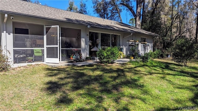 rear view of property with a sunroom and a yard