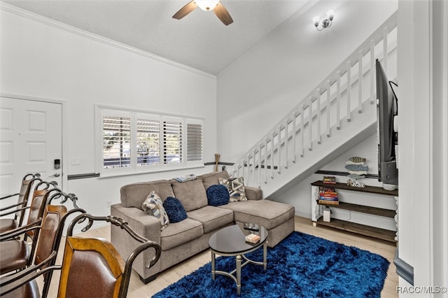 living room with ornamental molding, a textured ceiling, ceiling fan, light hardwood / wood-style flooring, and lofted ceiling