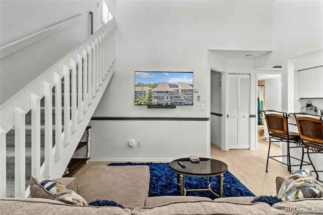 living room featuring a high ceiling and light wood-type flooring