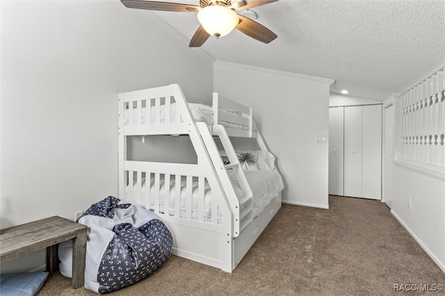 carpeted bedroom with a textured ceiling, a closet, ceiling fan, and crown molding