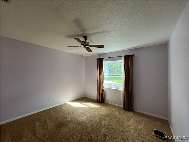 carpeted spare room with ceiling fan and a textured ceiling