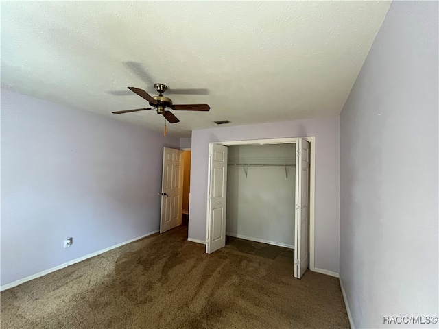 unfurnished bedroom with ceiling fan, a closet, dark carpet, and a textured ceiling