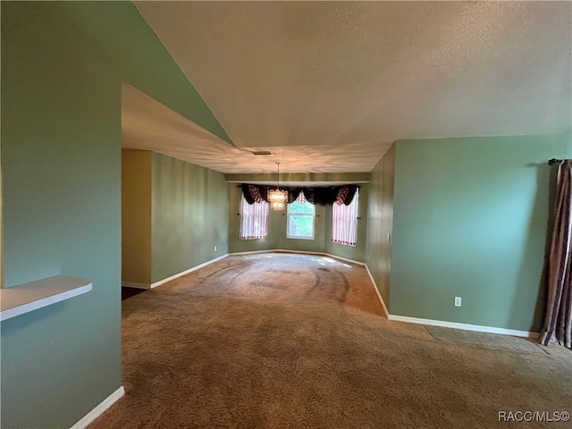 empty room featuring lofted ceiling, a notable chandelier, and carpet flooring