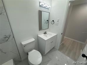 bathroom featuring hardwood / wood-style floors, vanity, and toilet