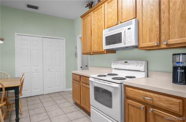 kitchen with light tile patterned flooring and white appliances