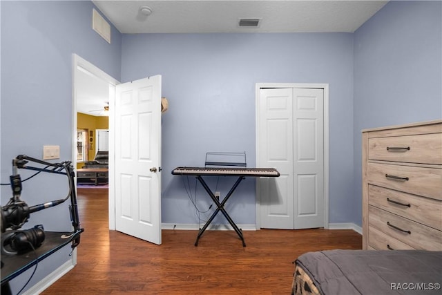 bedroom with a closet and dark hardwood / wood-style flooring