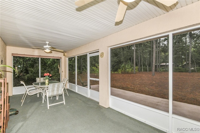 unfurnished sunroom featuring ceiling fan