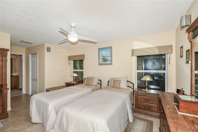 bedroom with ceiling fan, a closet, light tile patterned floors, and a textured ceiling