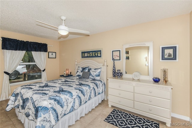 bedroom with a textured ceiling, ceiling fan, and light tile patterned flooring