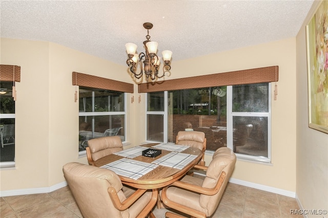 tiled dining area featuring a notable chandelier and a textured ceiling