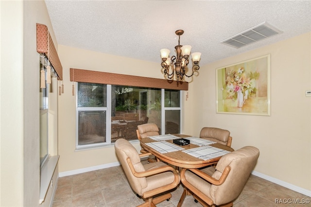 dining room with light tile patterned floors, a textured ceiling, and a chandelier