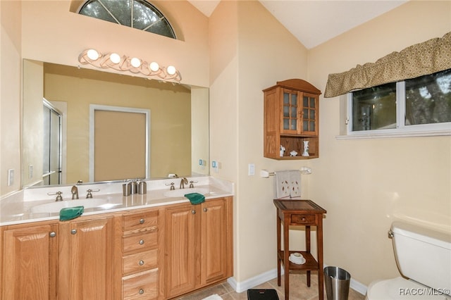 bathroom featuring vanity, toilet, and lofted ceiling