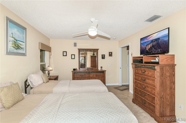 carpeted bedroom with ceiling fan and a textured ceiling