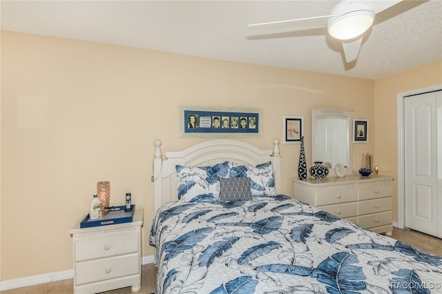 carpeted bedroom featuring a textured ceiling and ceiling fan