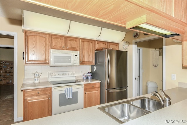 kitchen featuring backsplash, sink, and white appliances