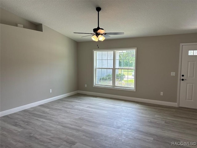 10185 N Halsey Way, Citrus Springs, FL 34434 - spare room with wood finished floors, a textured ceiling, a ceiling fan, and baseboards