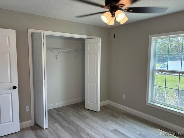 10185 N Halsey Way, Citrus Springs, FL 34434 - unfurnished bedroom featuring light wood-style flooring, a closet, baseboards, and ceiling fan