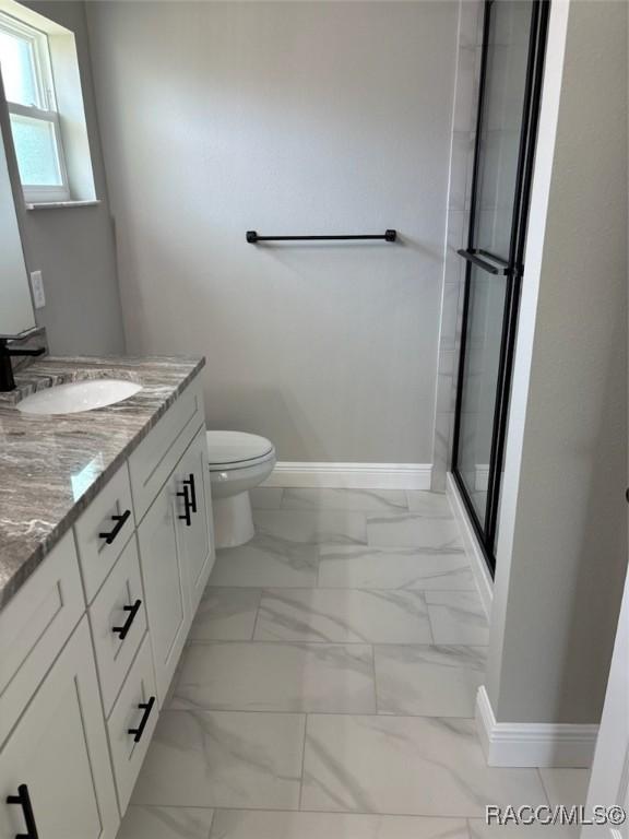 10185 N Halsey Way, Citrus Springs, FL 34434 - bathroom featuring marble look tiles, vanity, baseboards, and toilet