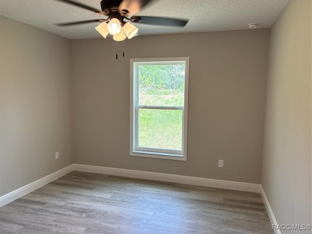 10185 N Halsey Way, Citrus Springs, FL 34434 - spare room featuring a textured ceiling, wood finished floors, ceiling fan, baseboards, and a smoke detector