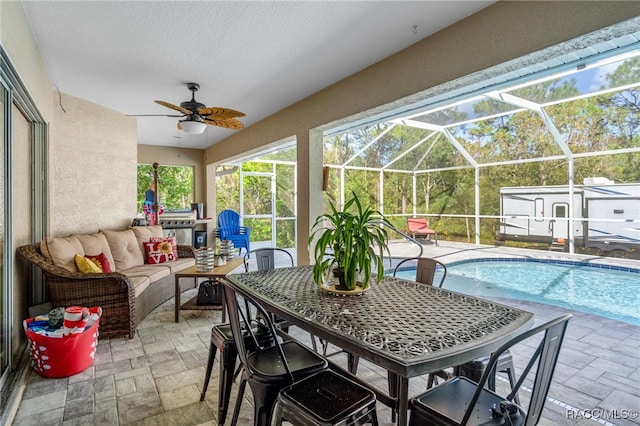 sunroom featuring ceiling fan and a pool