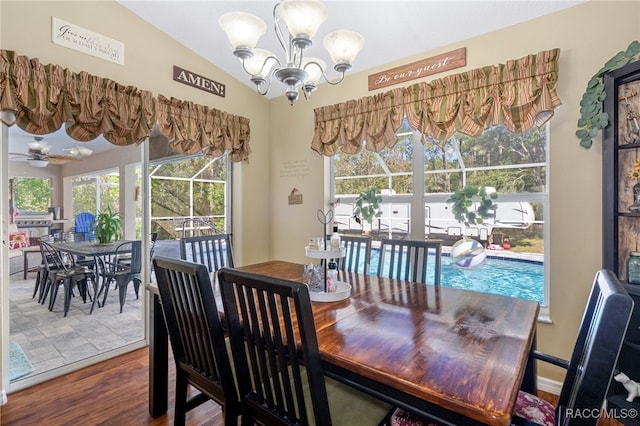 dining area featuring ceiling fan with notable chandelier, hardwood / wood-style flooring, plenty of natural light, and lofted ceiling