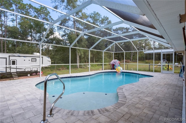 view of swimming pool with a patio, glass enclosure, and a lawn