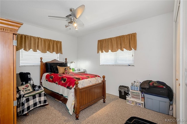 bedroom featuring ceiling fan, light colored carpet, and multiple windows