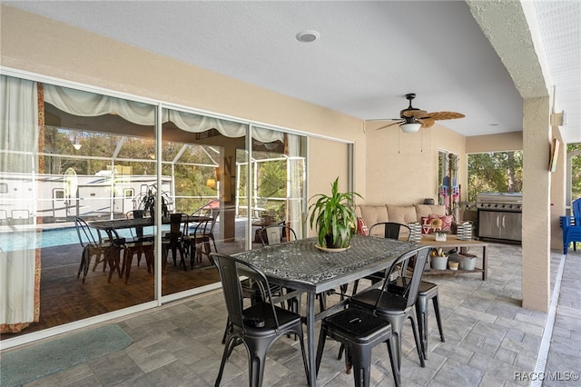 dining area featuring ceiling fan and a textured ceiling