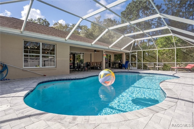 view of pool with a lanai, a patio area, and ceiling fan